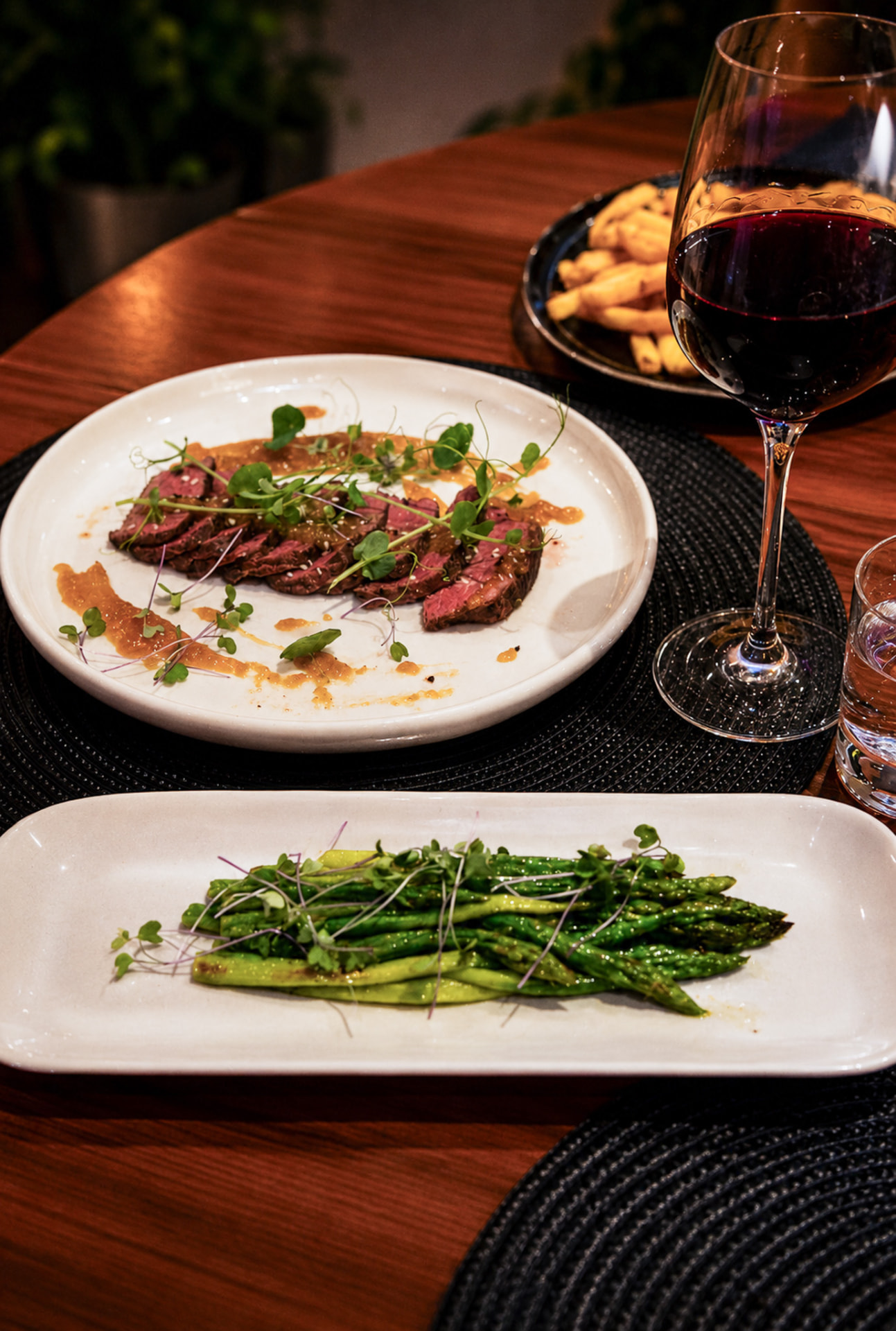 Bœuf grillé et asperges vertes, verre de vin rouge