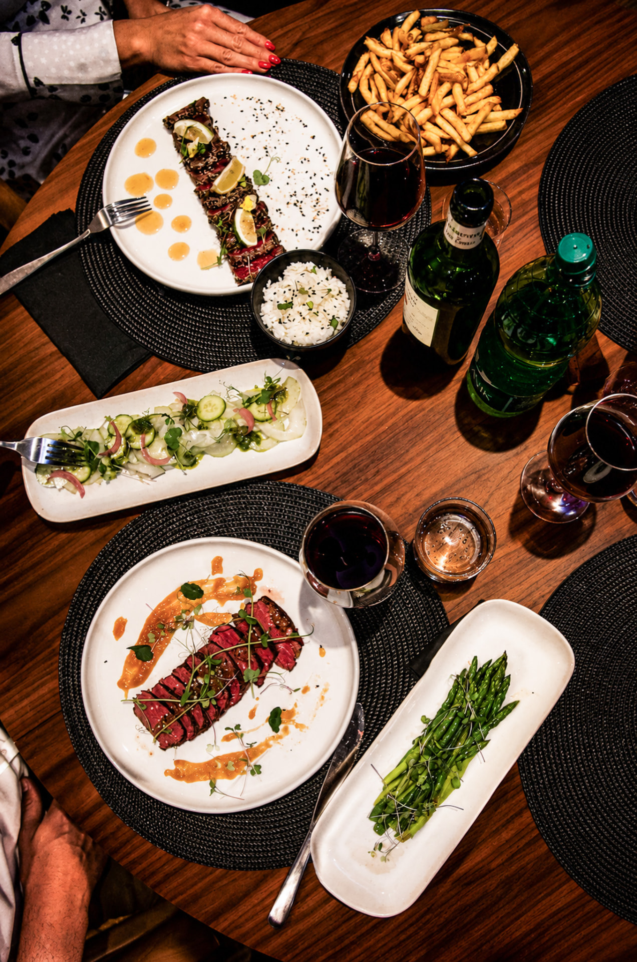 Table dressée : tataki de bœuf, salade de concombre et vins