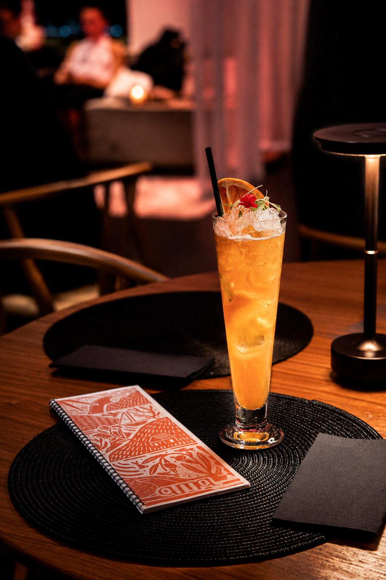 Cocktail orange glacé et carte AMA sur la table